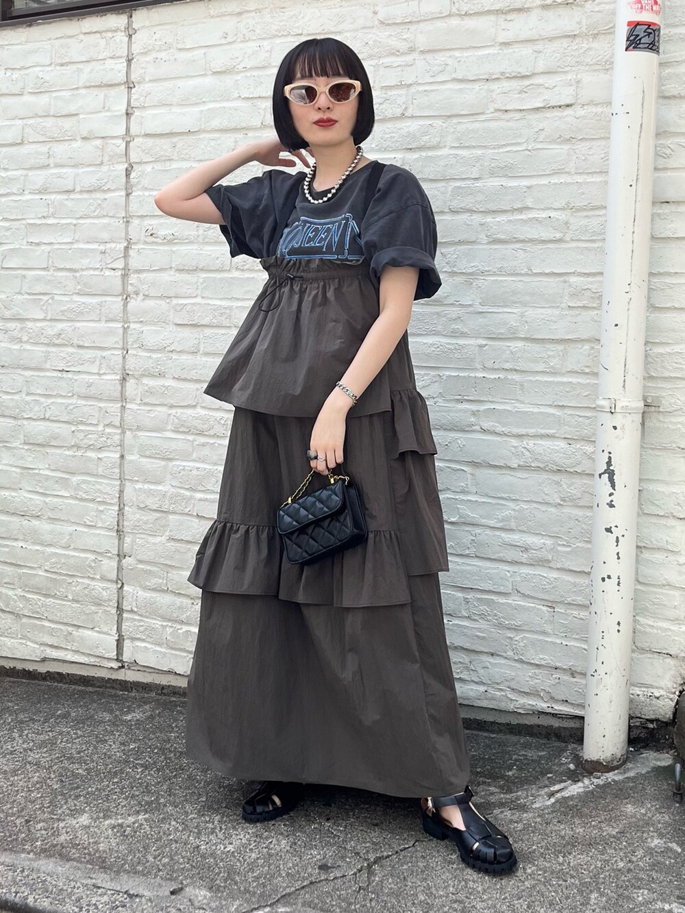 ブラック系のTシャツ/カットソー、グリーン系のワンピース、ブラック系のショルダーバッグを着用したレディースの春コーディネートの2枚目の写真