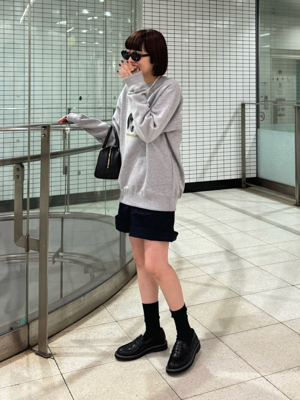 グレー系のスウェット、ブラック系のボストンバッグ、ブラック系のローファーを着用したレディースの春コーディネートの6枚目の写真