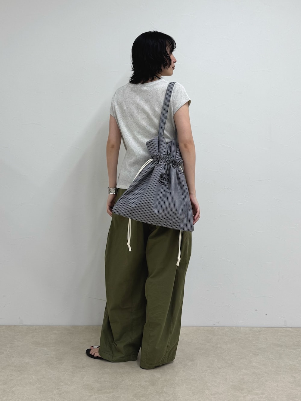 ホワイト系のTシャツ/カットソー、ブラック系のトートバッグ、グリーン系のその他パンツを着用したレディースの夏コーディネートの3枚目の写真