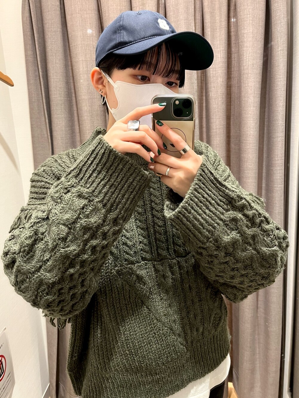 グリーン系のニット/セーター、ブラック系のデニムパンツを着用したレディースの冬コーディネートの2枚目の写真