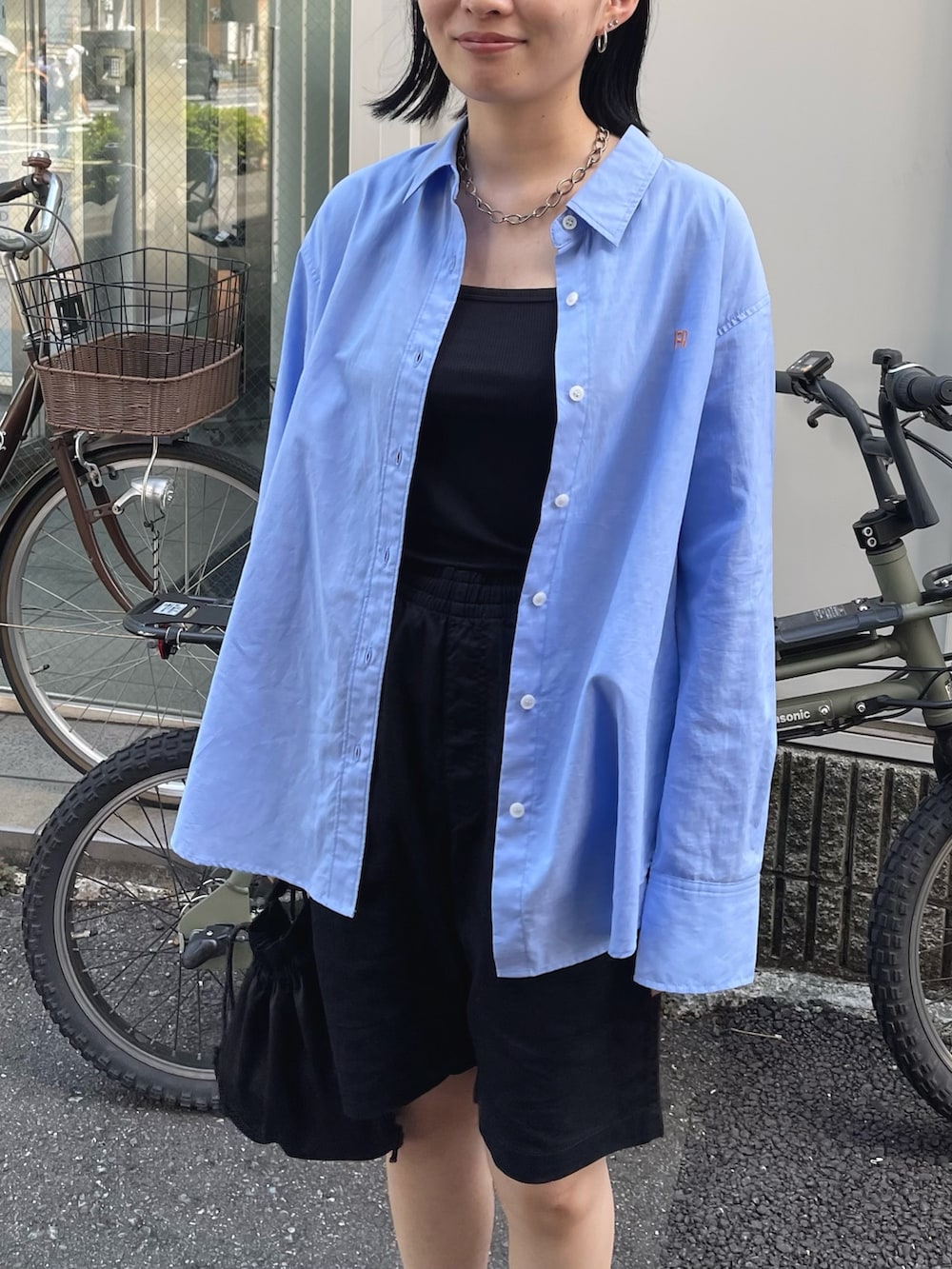 ブルー系のシャツ/ブラウス、ブラック系のサンダル、ブラック系のショルダーバッグを着用したレディースの秋コーディネートの3枚目の写真