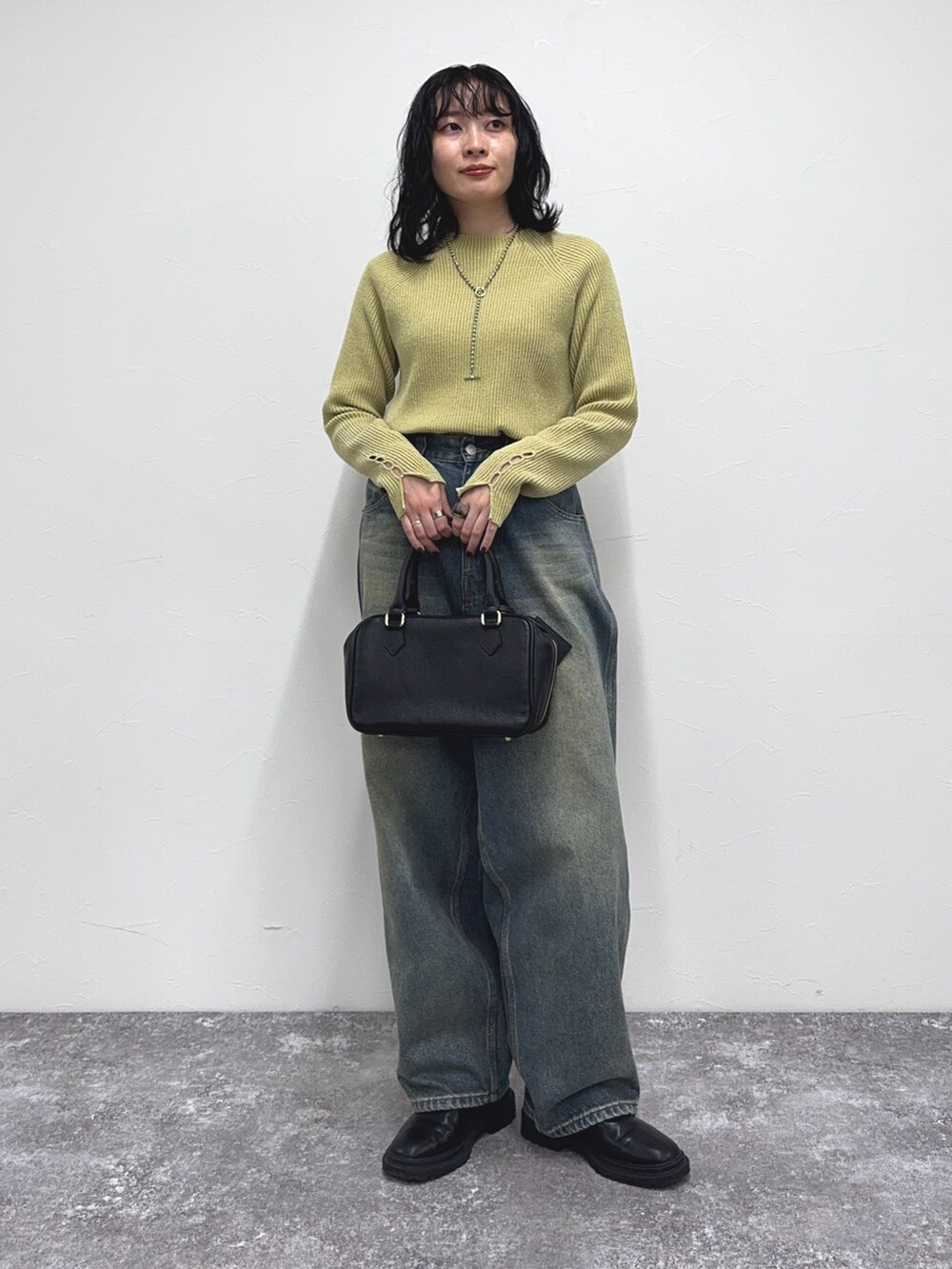 イエロー系のその他トップス、ブルー系のデニムパンツを着用したレディースの冬コーディネートの2枚目の写真