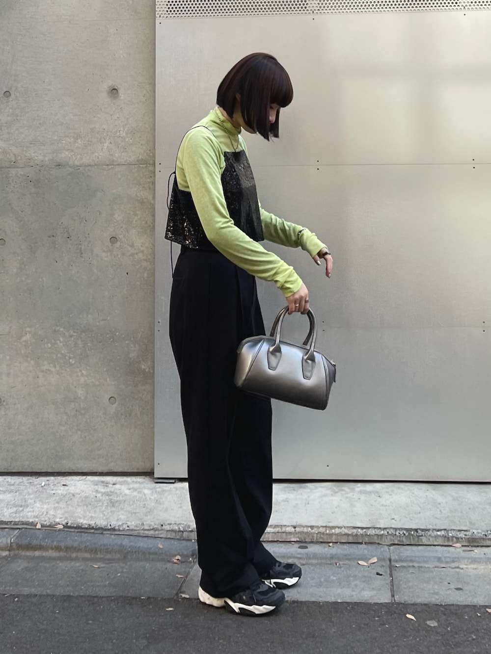 ブラック系のシャツ/ブラウス、グリーン系のトップス、ブラック系のスラックスを着用したレディースの冬コーディネートの2枚目の写真