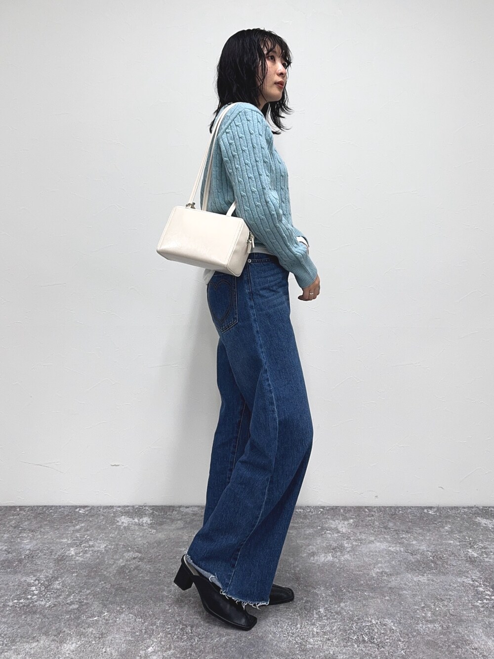 ブルー系のニット/セーター、ブルー系のデニムパンツ、ホワイト系のTシャツ/カットソーを着用したレディースの冬コーディネートの4枚目の写真