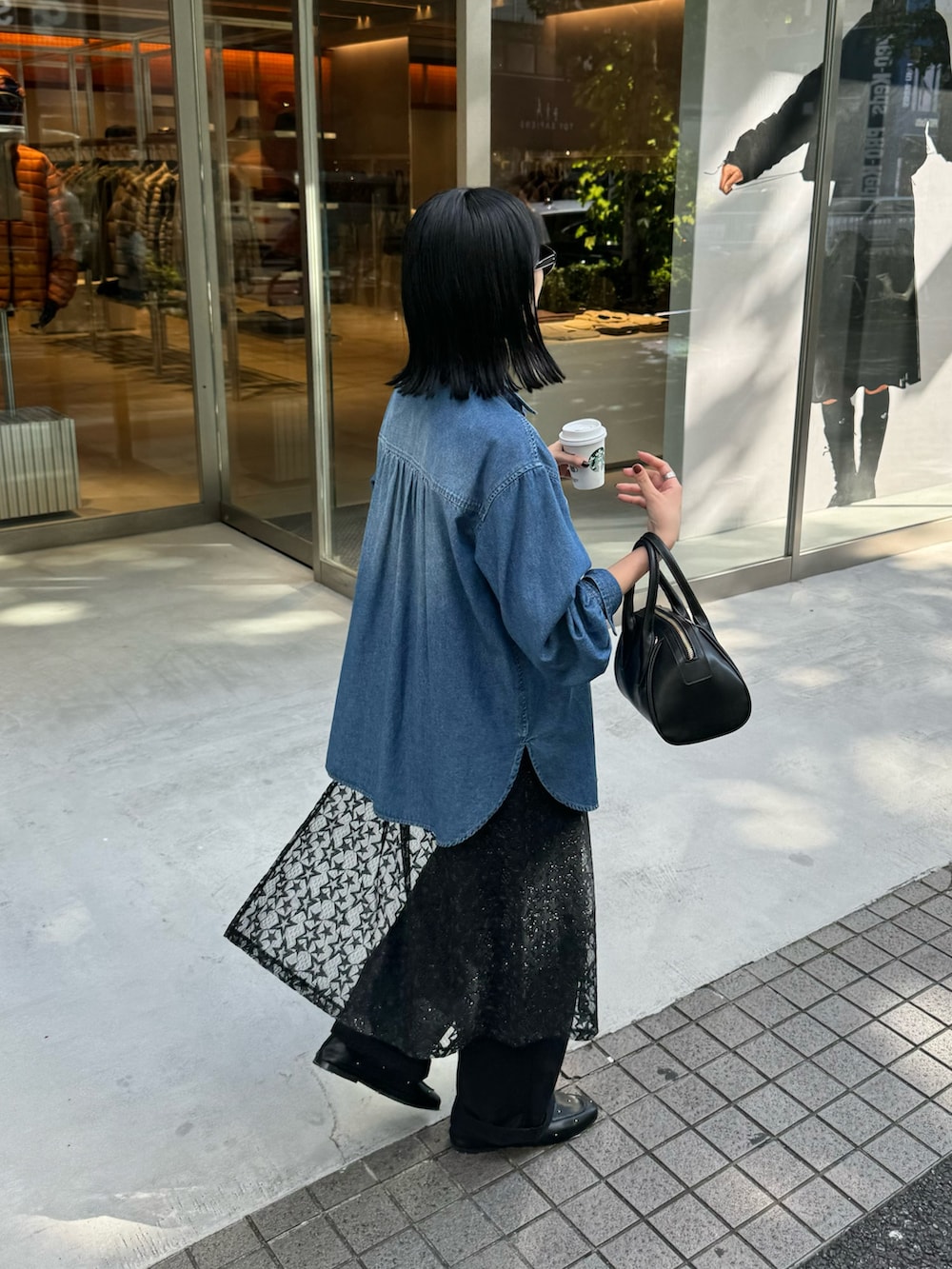ブルー系のシャツ/ブラウス、ブルー系のチノパンツ、ブラック系のスカートを着用したレディースの秋コーディネートの6枚目の写真