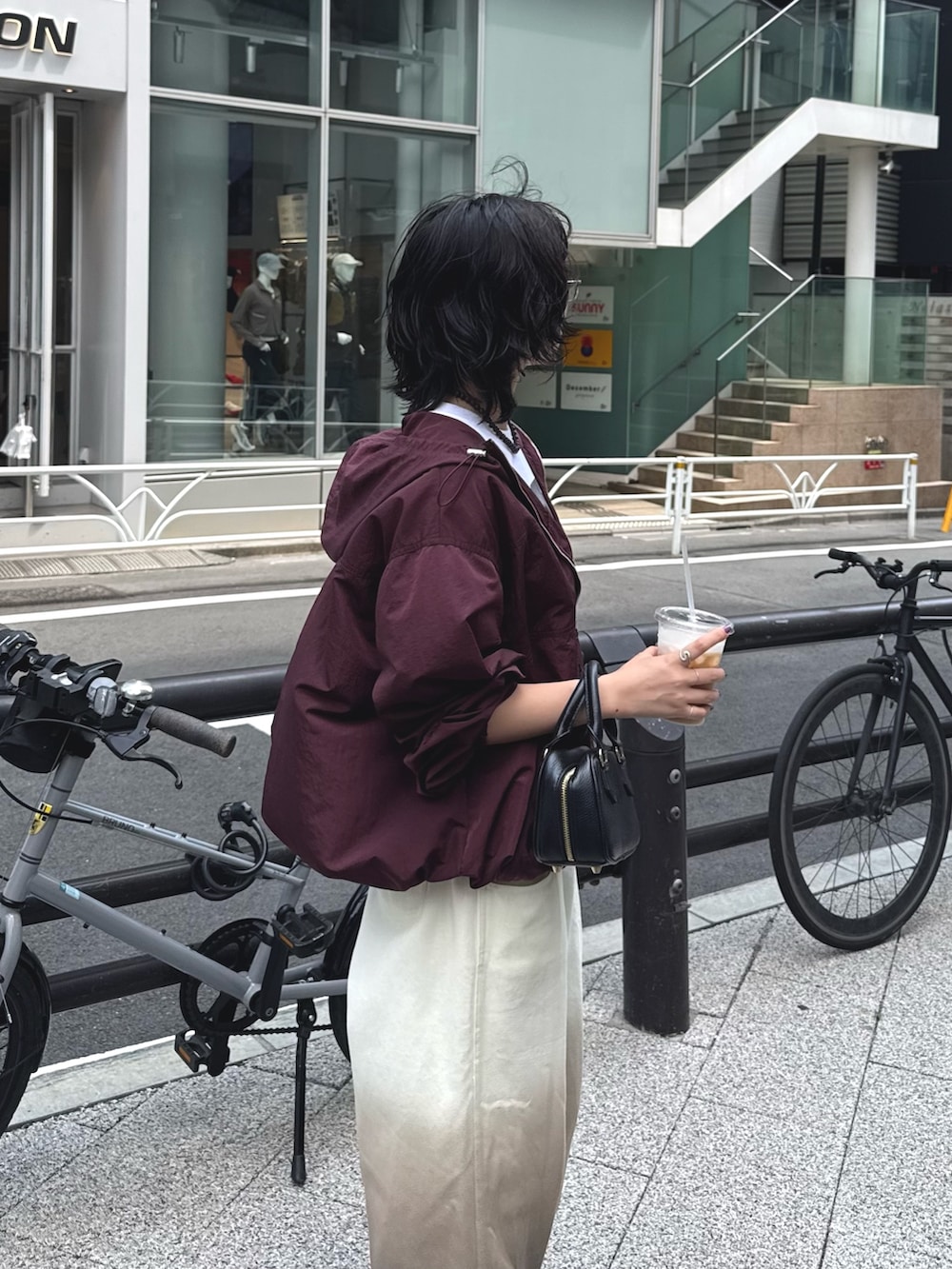 レッド系のブルゾン、ホワイト系のTシャツ/カットソー、ブラウン系のデニムパンツを着用したレディースの秋コーディネートの5枚目の写真