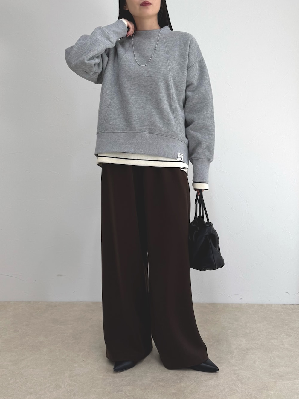 グレー系のスウェット、ブラウン系のその他パンツ、ホワイト系のTシャツ/カットソーを着用したレディースの冬コーディネートの5枚目の写真