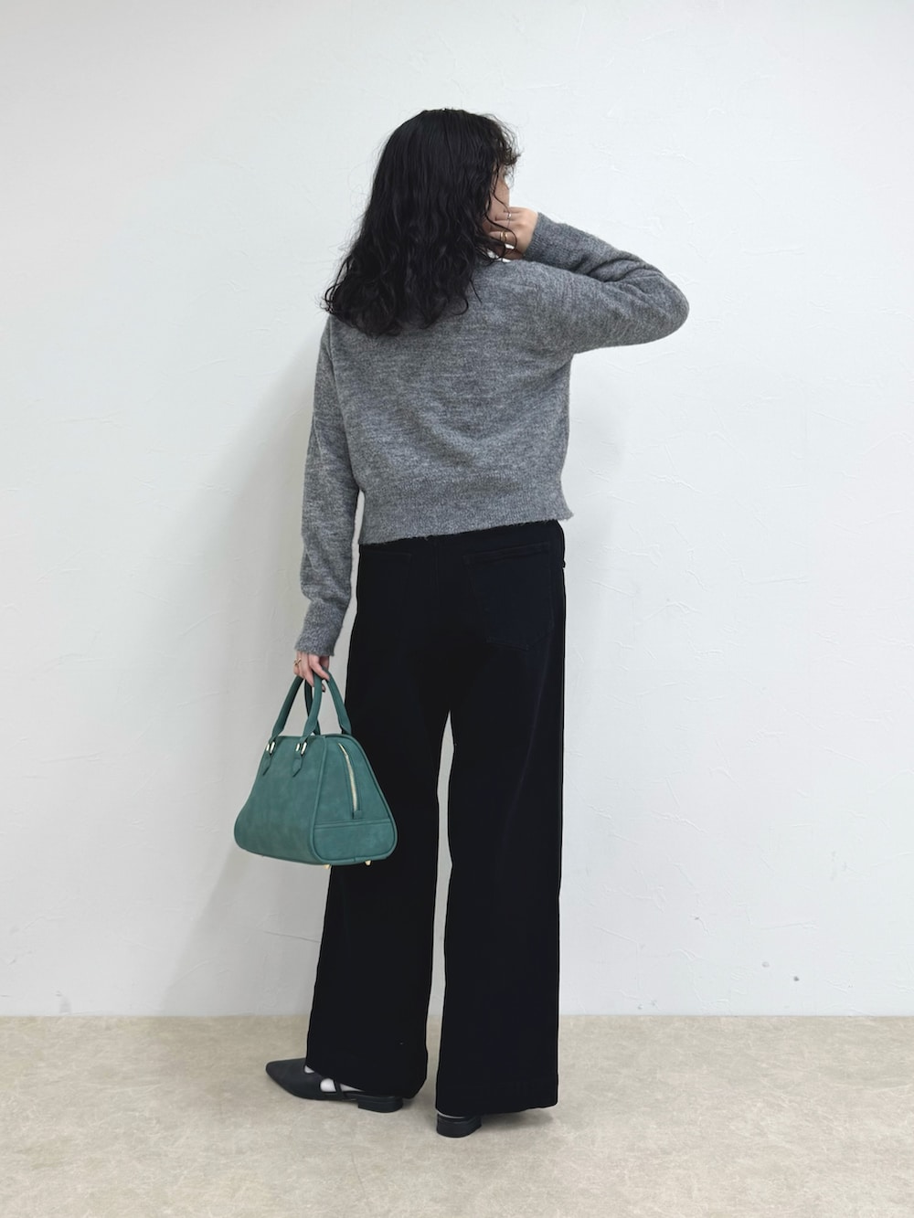 グレー系のカーディガン/ボレロ、グリーン系のショルダーバッグ、ブルー系のデニムパンツを着用したレディースの秋コーディネートの5枚目の写真