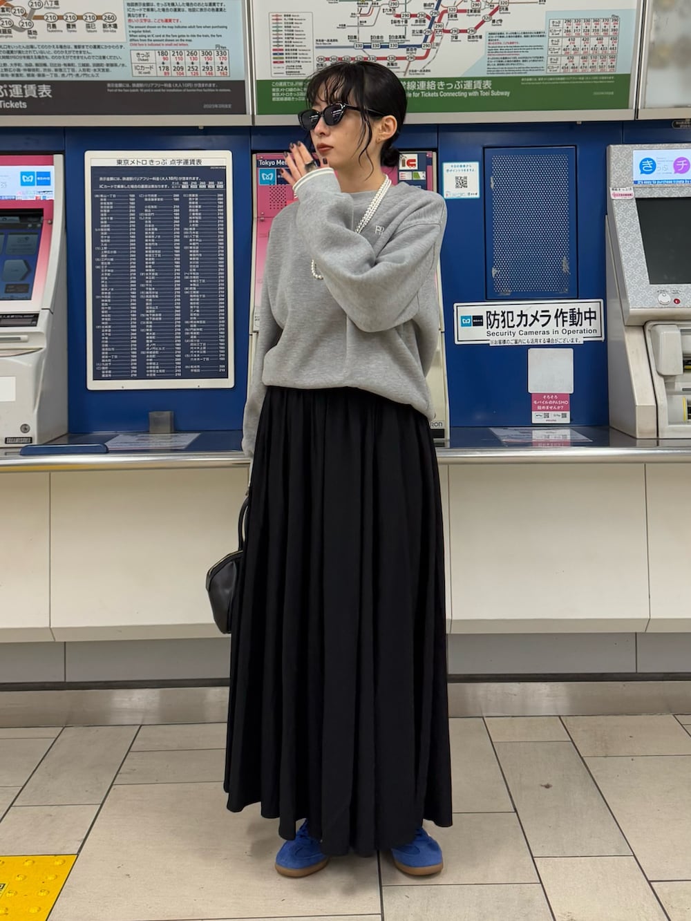 グレー系のスウェット、ブラック系のスカートを着用したレディースの冬コーディネートの3枚目の写真