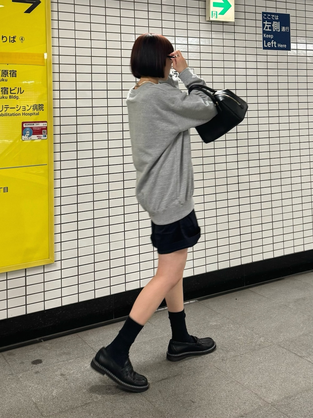 グレー系のスウェット、ブラック系のボストンバッグ、ブラック系のローファーを着用したレディースの春コーディネートの2枚目の写真