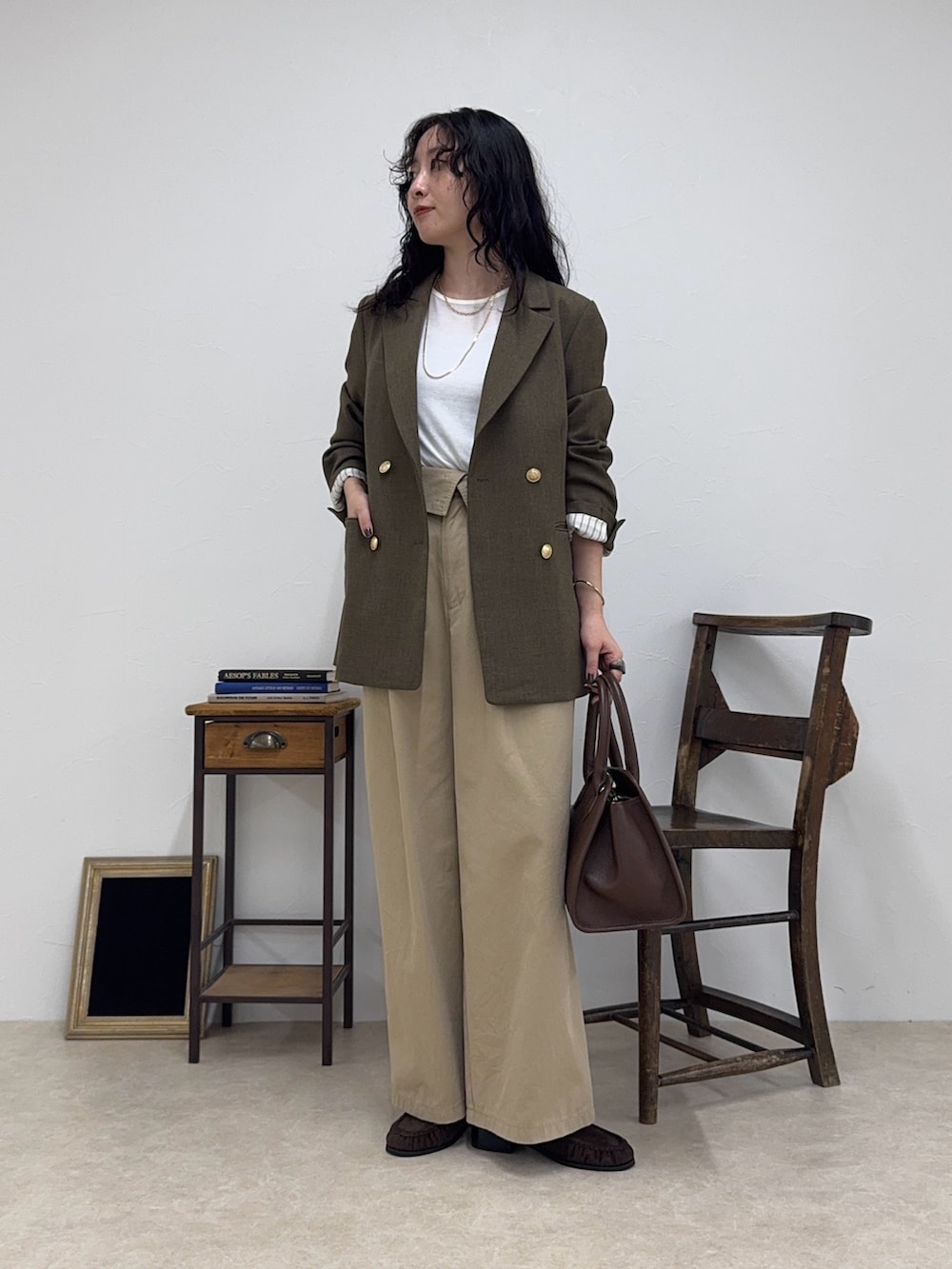 ブラウン系のテーラードジャケット、ホワイト系のTシャツ/カットソー、ベージュ系のチノパンツを着用したレディースの秋コーディネートの2枚目の写真