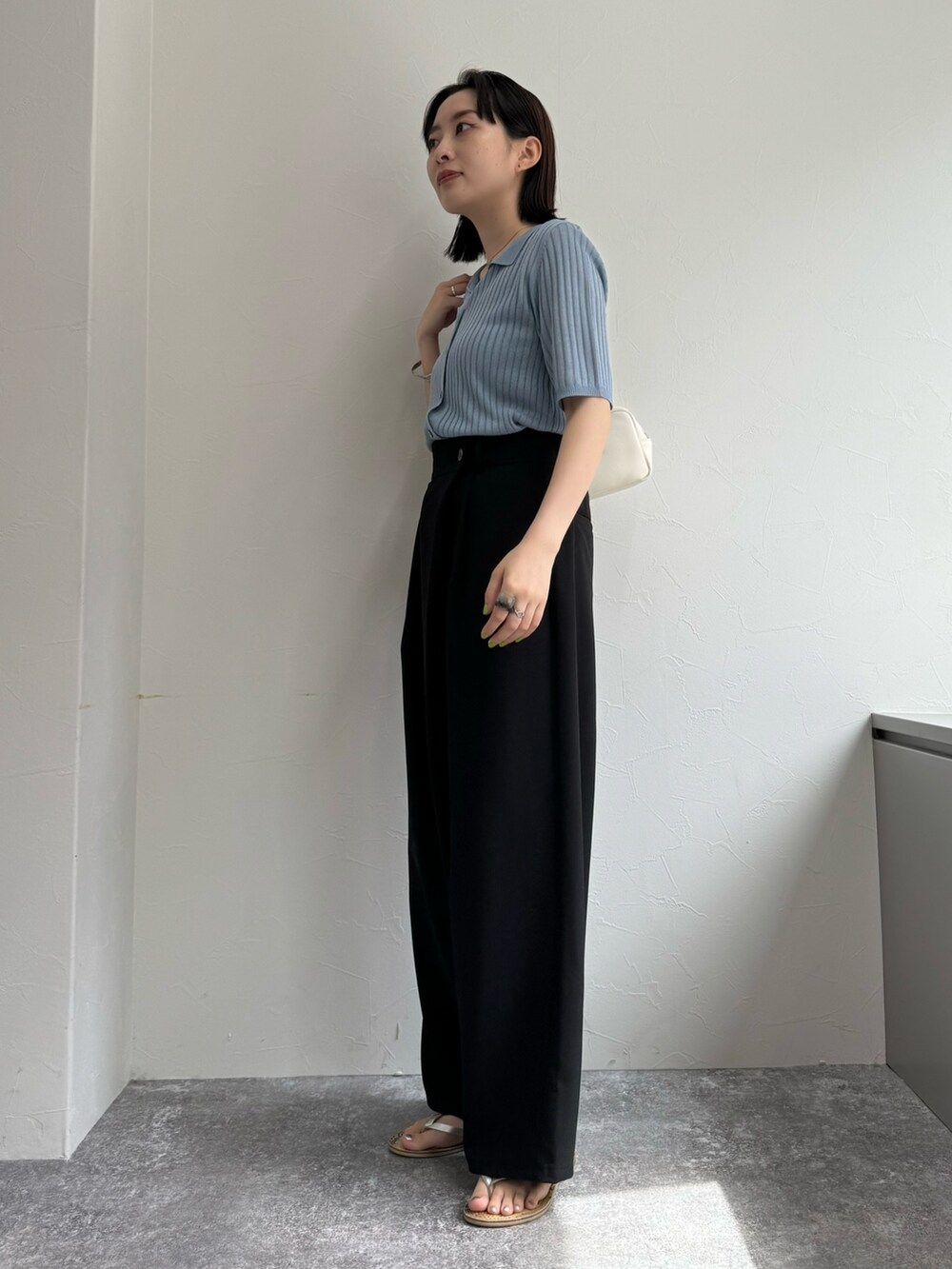 ブルー系のカーディガン/ボレロ、ブラック系のその他パンツ、ホワイト系のボストンバッグを着用したレディースの春コーディネートの2枚目の写真