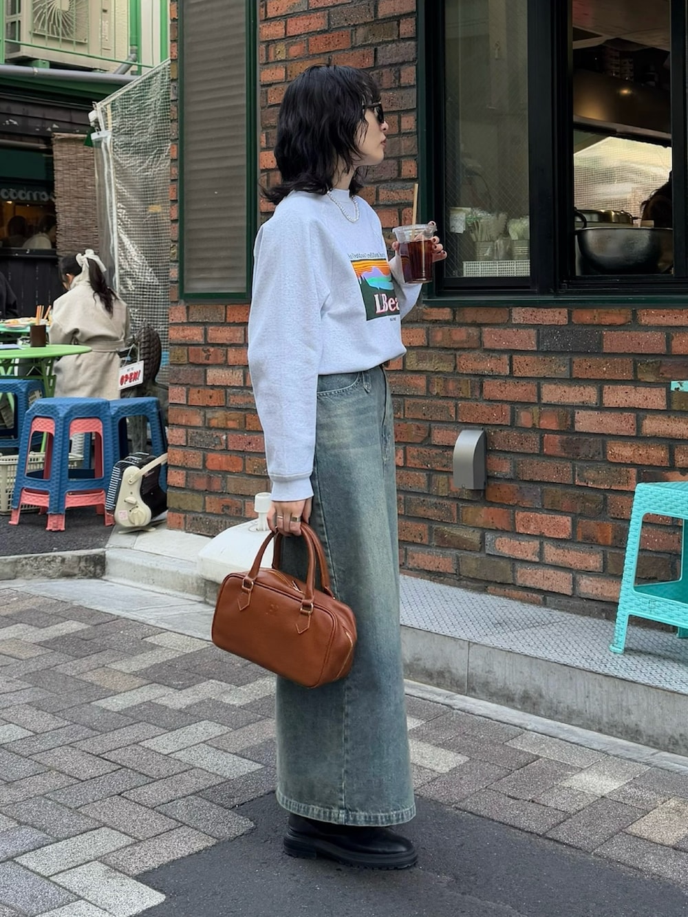 ブルー系のデニムスカート、イエロー系のショルダーバッグを着用したレディースの冬コーディネートの6枚目の写真