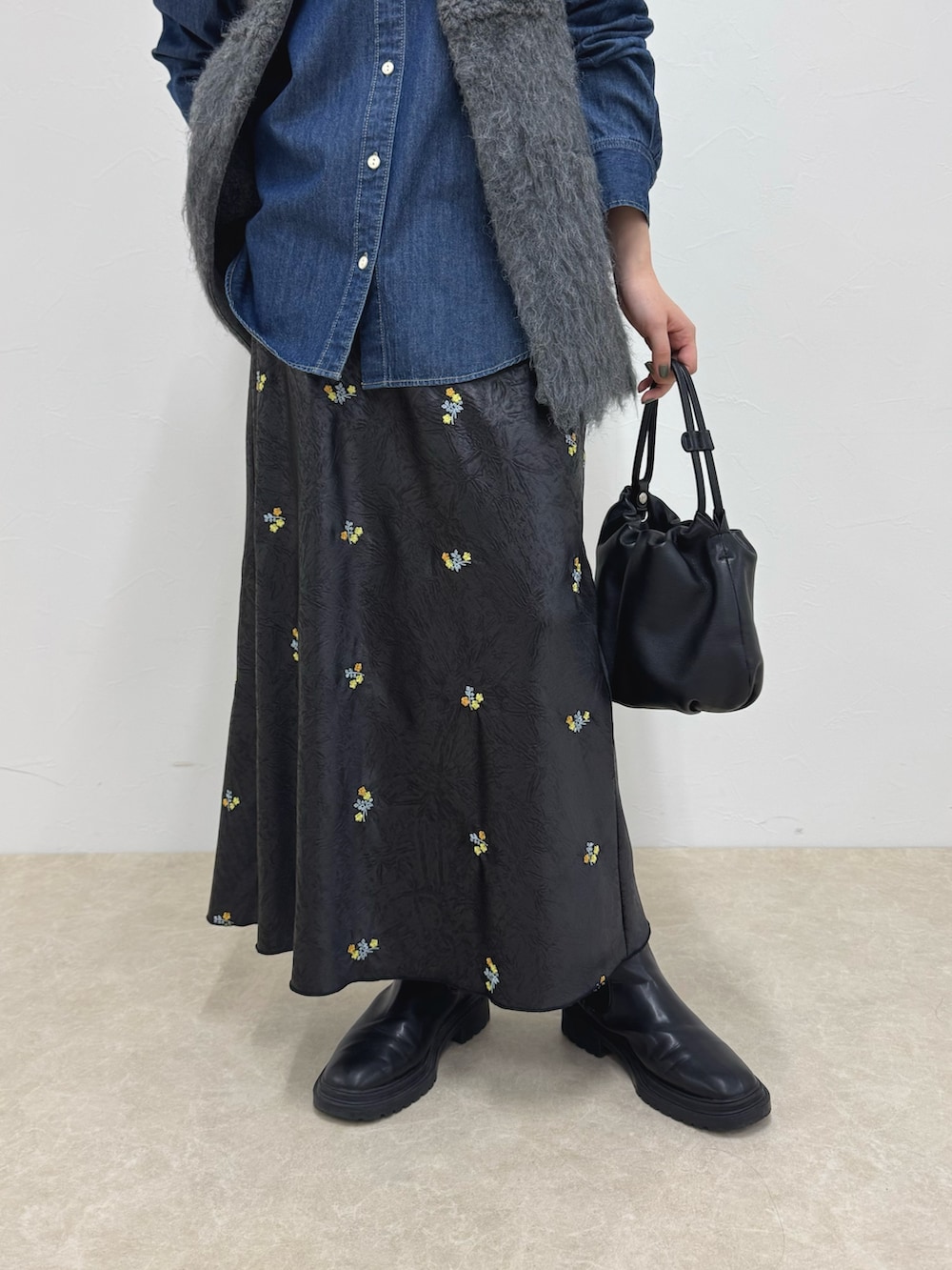 ブルー系のシャツ/ブラウス、グレー系のベスト、ブラック系のスカートを着用したレディースの秋コーディネートの5枚目の写真