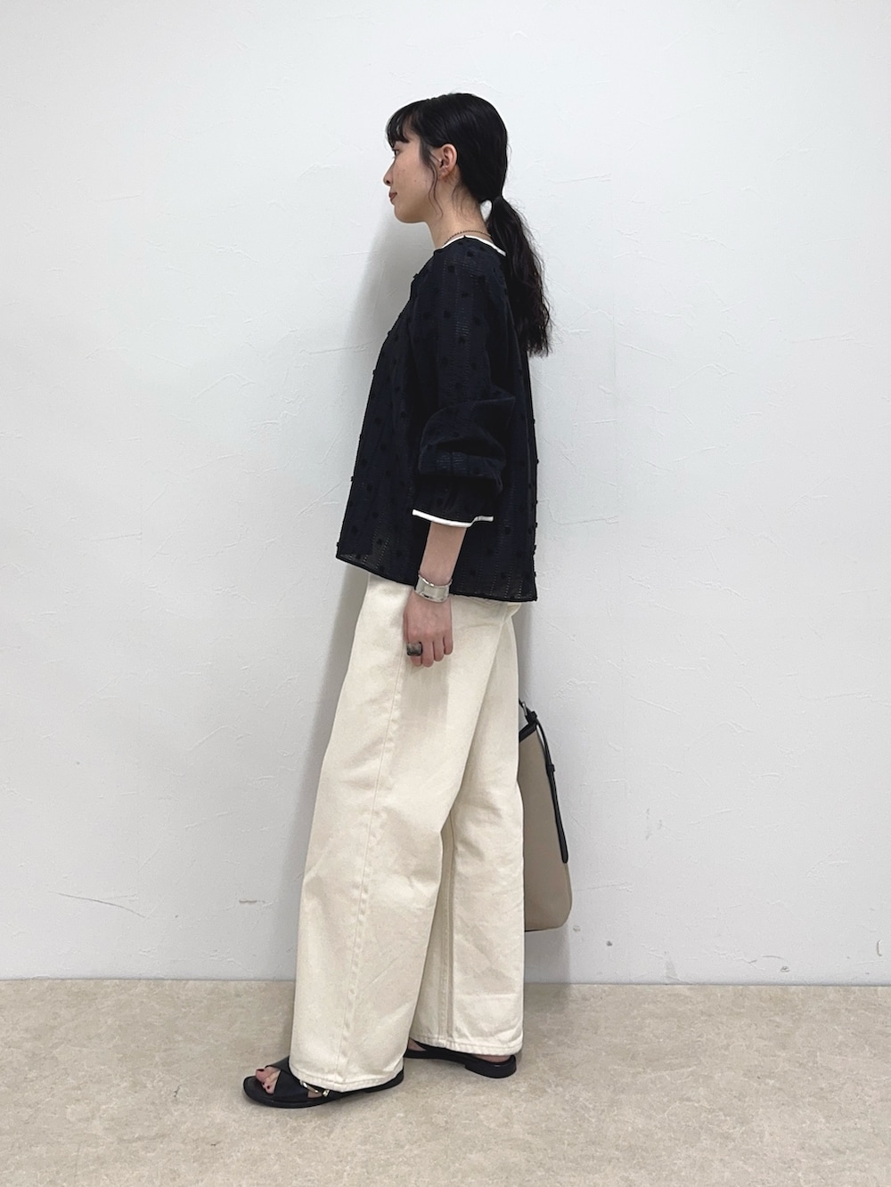 ブラック系のシャツ/ブラウス、ホワイト系のデニムパンツ、ブラック系のショルダーバッグを着用したレディースの春コーディネートの3枚目の写真