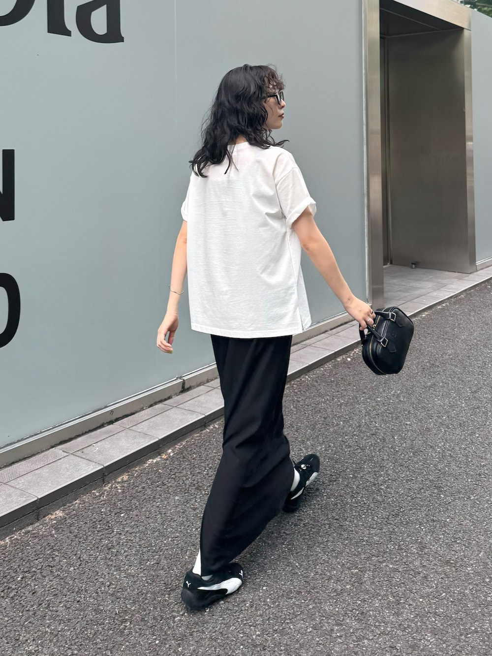 ホワイト系のTシャツ/カットソー、ブラック系のスカート、ブラック系のショルダーバッグを着用したレディースの夏コーディネートの5枚目の写真
