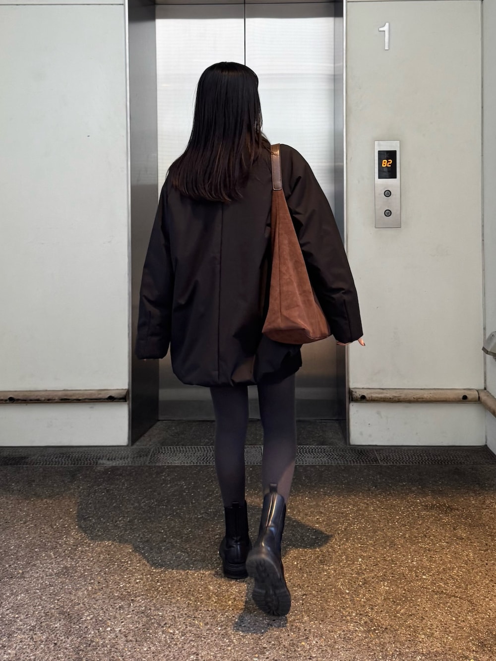 ブラック系のダッフルコート、グレー系のニット/セーターを着用したレディースの秋コーディネートの2枚目の写真