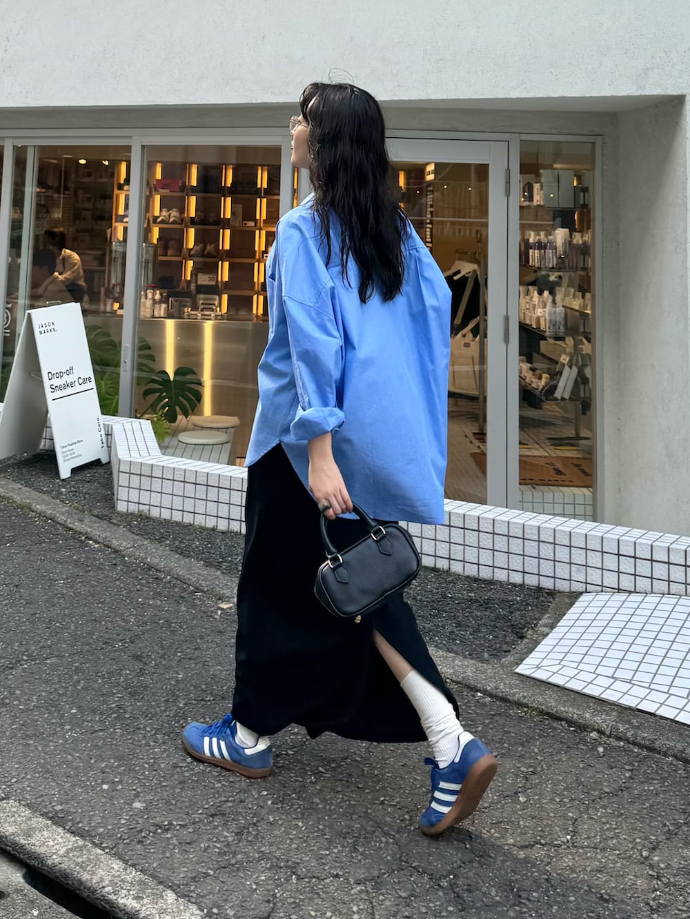 ブルー系のシャツ/ブラウス、グレー系のタンクトップ、ブラック系のスカートを着用したレディースの春コーディネートの2枚目の写真