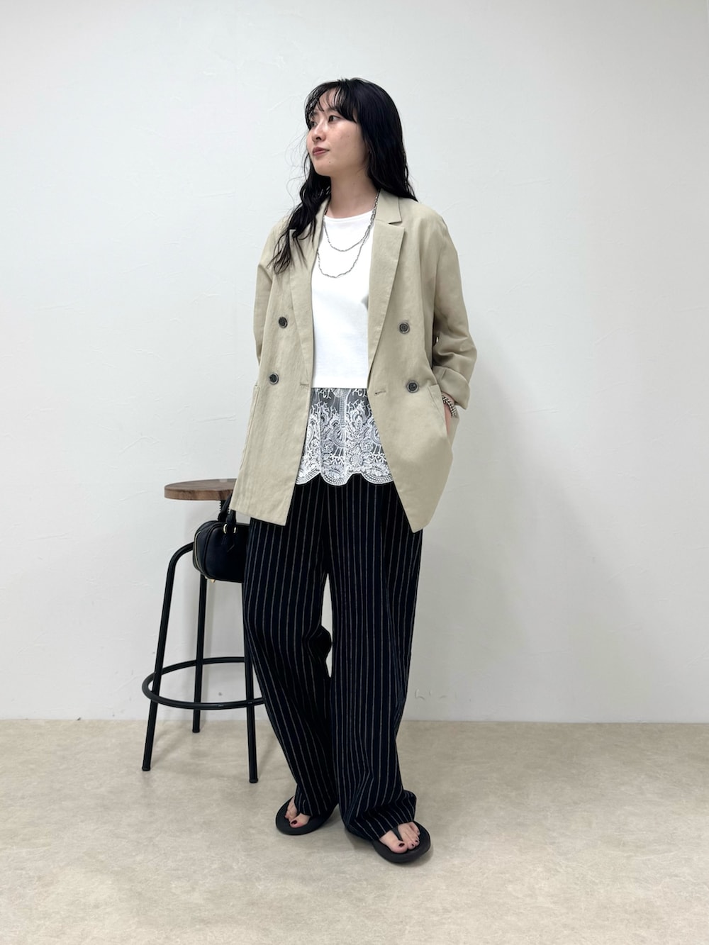 ブラック系のその他パンツ、ブラック系のサンダル、ホワイト系のTシャツ/カットソーを着用したレディースの春コーディネートの6枚目の写真