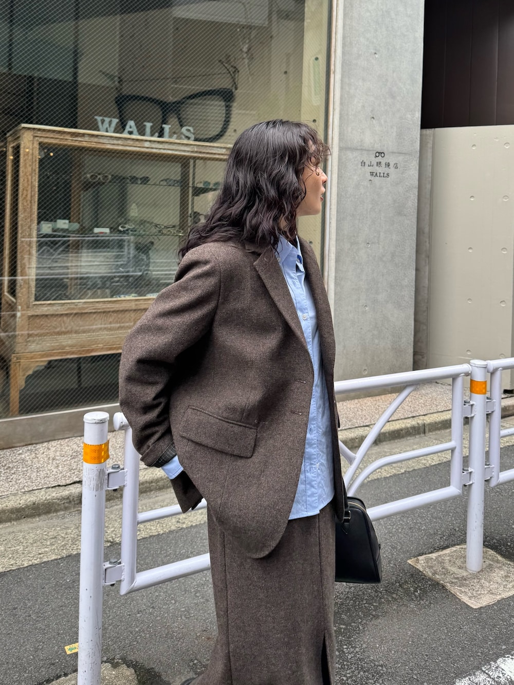 ブラウン系のテーラードジャケット、ブルー系のシャツ/ブラウス、ブラウン系のスカートを着用したレディースの秋コーディネートの5枚目の写真