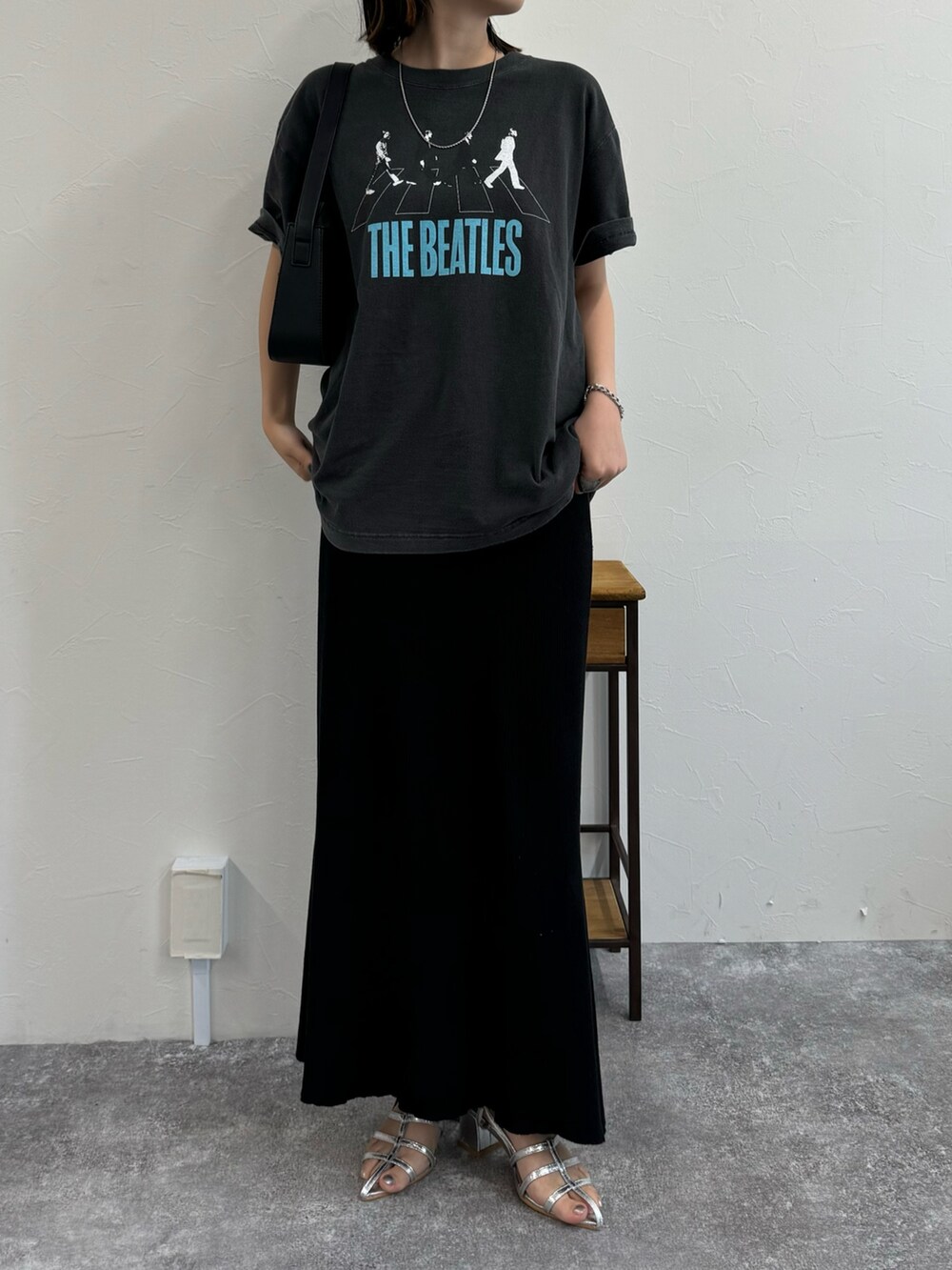 ブラック系のスカート、シルバー系のサンダル、グレー系のTシャツ/カットソーを着用したレディースの夏コーディネートの2枚目の写真