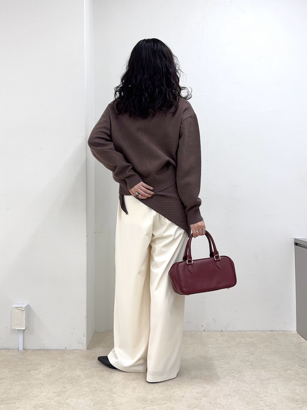 ブラウン系のニット/セーター、ホワイト系のその他パンツ、レッド系のショルダーバッグを着用したレディースの秋コーディネートの4枚目の写真