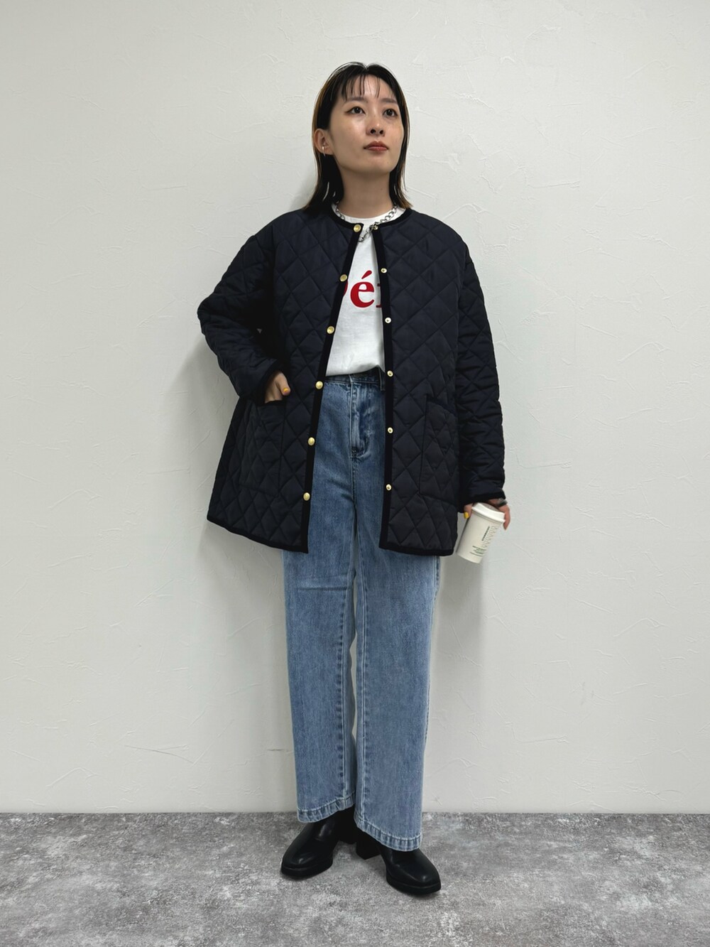 ブラック系のブルゾン、ホワイト系のTシャツ/カットソー、ブルー系のデニムパンツを着用したレディースの夏コーディネートの4枚目の写真