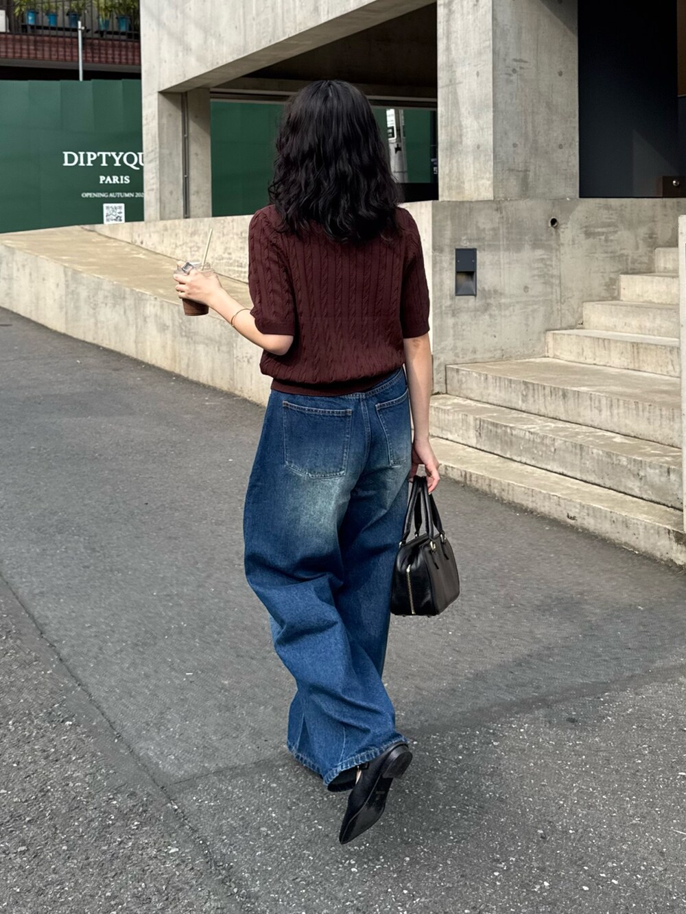 ブラウン系のニット/セーター、ブルー系のデニムパンツ、ブラック系のショルダーバッグを着用したレディースの夏コーディネートの3枚目の写真