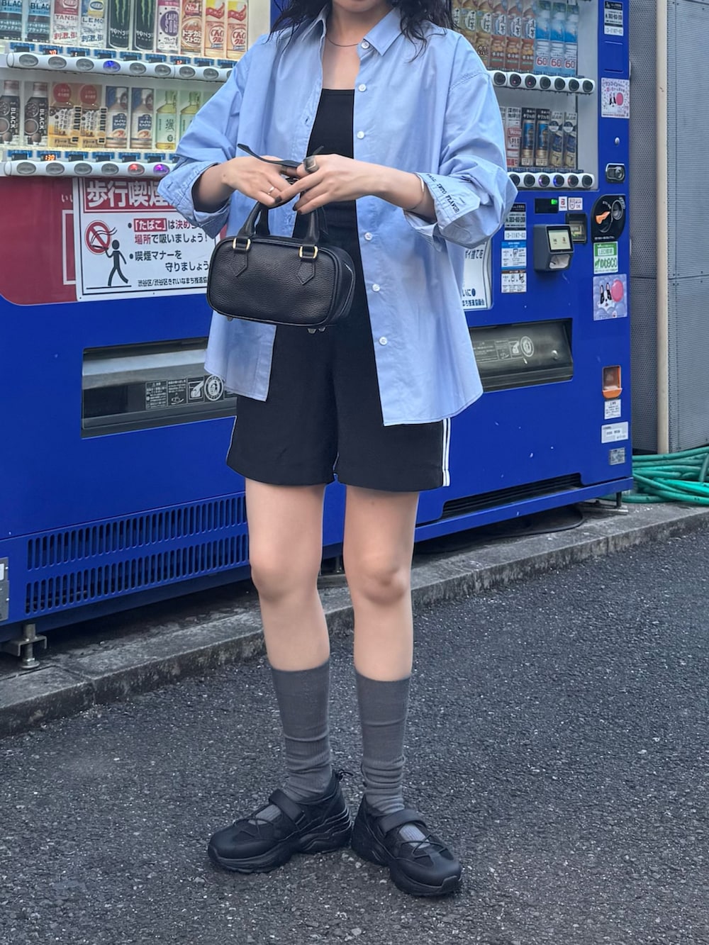 ブルー系のシャツ/ブラウス、ブラック系のスニーカー、ブラック系のショルダーバッグを着用したレディースの夏コーディネートの5枚目の写真