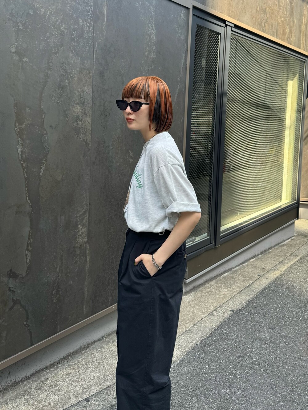 グレー系のTシャツ/カットソー、ブラック系のチノパンツを着用したレディースの春コーディネートの6枚目の写真