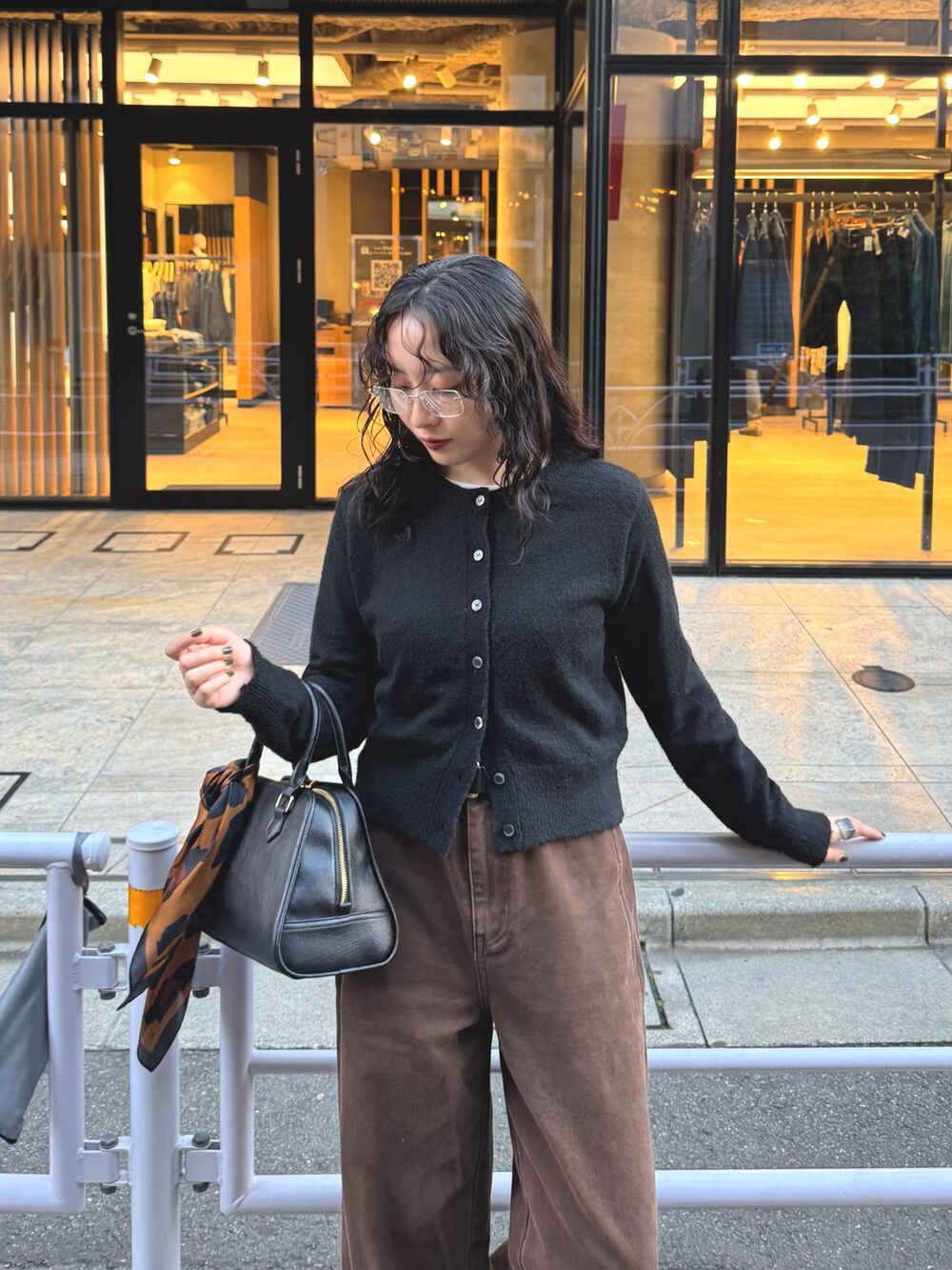 ブラック系のカーディガン/ボレロ、ブラウン系のその他パンツ、ブラック系のショルダーバッグを着用したレディースの秋コーディネートの7枚目の写真