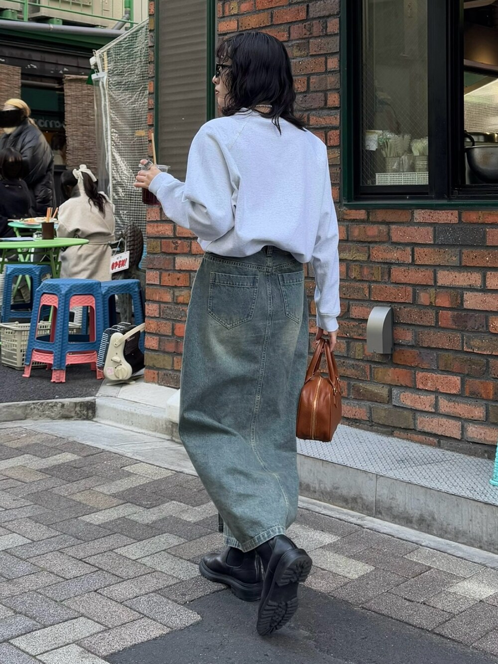 ブルー系のデニムスカート、イエロー系のショルダーバッグを着用したレディースの冬コーディネートの5枚目の写真