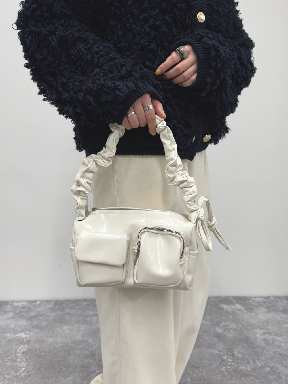 ブルー系のカーディガン/ボレロ、ホワイト系のその他パンツ、ホワイト系のハンドバッグを着用したレディースの冬コーディネートの8枚目の写真