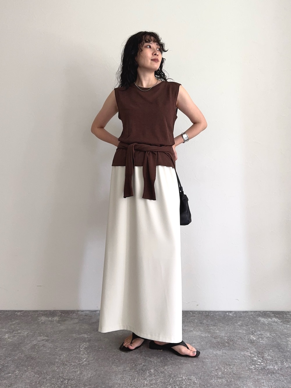 ブラウン系のタンクトップ、ブラウン系のカーディガン/ボレロ、ホワイト系のスカートを着用したレディースの夏コーディネートの2枚目の写真