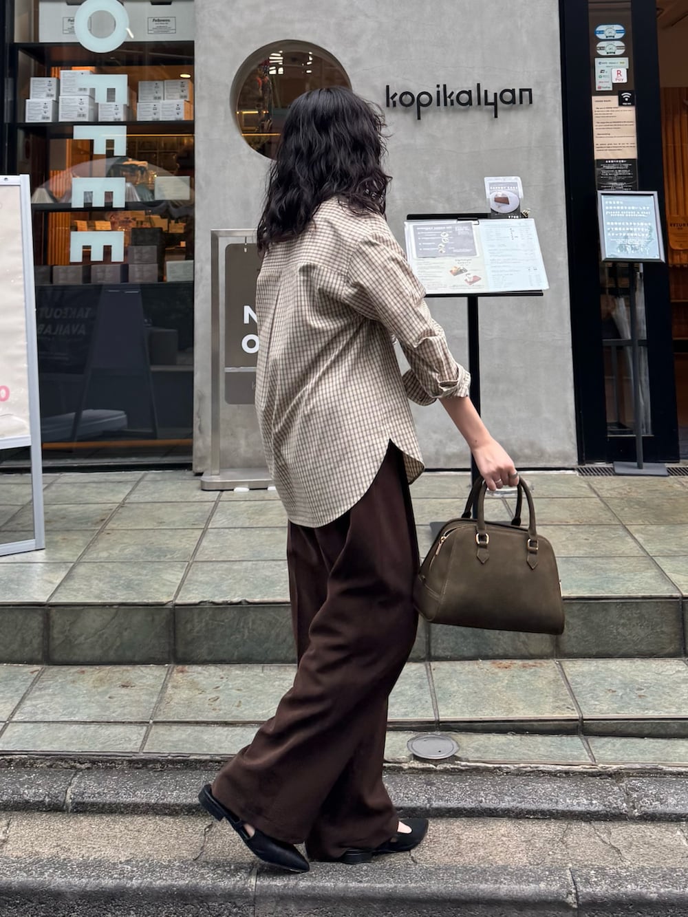 ベージュ系のシャツ/ブラウス、ブラウン系のスラックス、グリーン系のショルダーバッグを着用したレディースの秋コーディネートの2枚目の写真