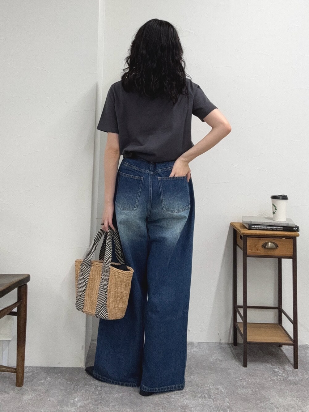 グレー系のTシャツ/カットソー、ブルー系のデニムパンツ、ベージュ系のかごバッグを着用したレディースの夏コーディネートの4枚目の写真