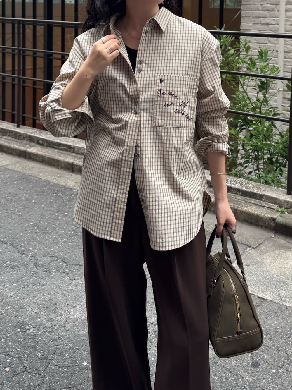 ベージュ系のシャツ/ブラウス、ブラウン系のスラックス、グリーン系のショルダーバッグを着用したレディースの秋コーディネートの4枚目の写真