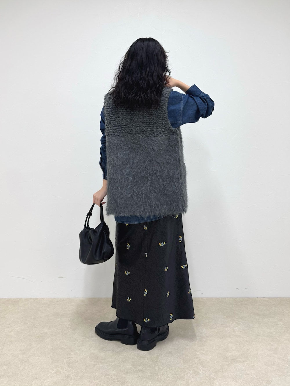 ブルー系のシャツ/ブラウス、グレー系のベスト、ブラック系のスカートを着用したレディースの秋コーディネートの4枚目の写真