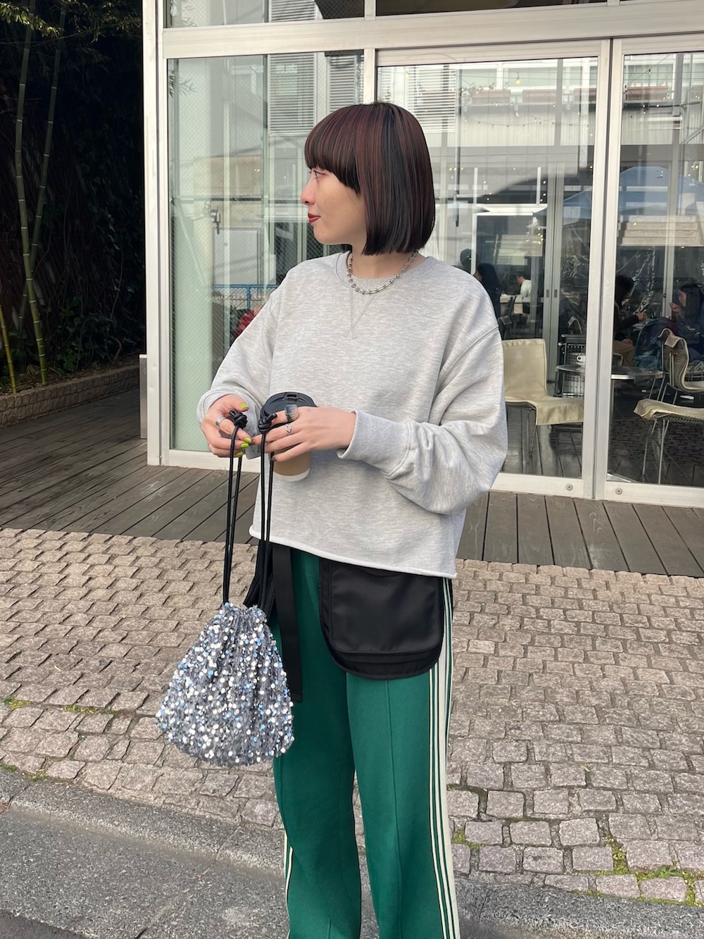 グレー系のスウェット、グレー系のショルダーバッグを着用したレディースの冬コーディネートの2枚目の写真