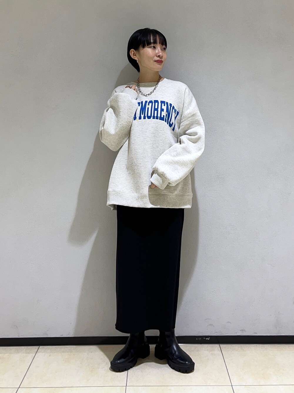 グレー系のスウェット、ブラック系のスカートを着用したレディースの冬コーディネートの2枚目の写真