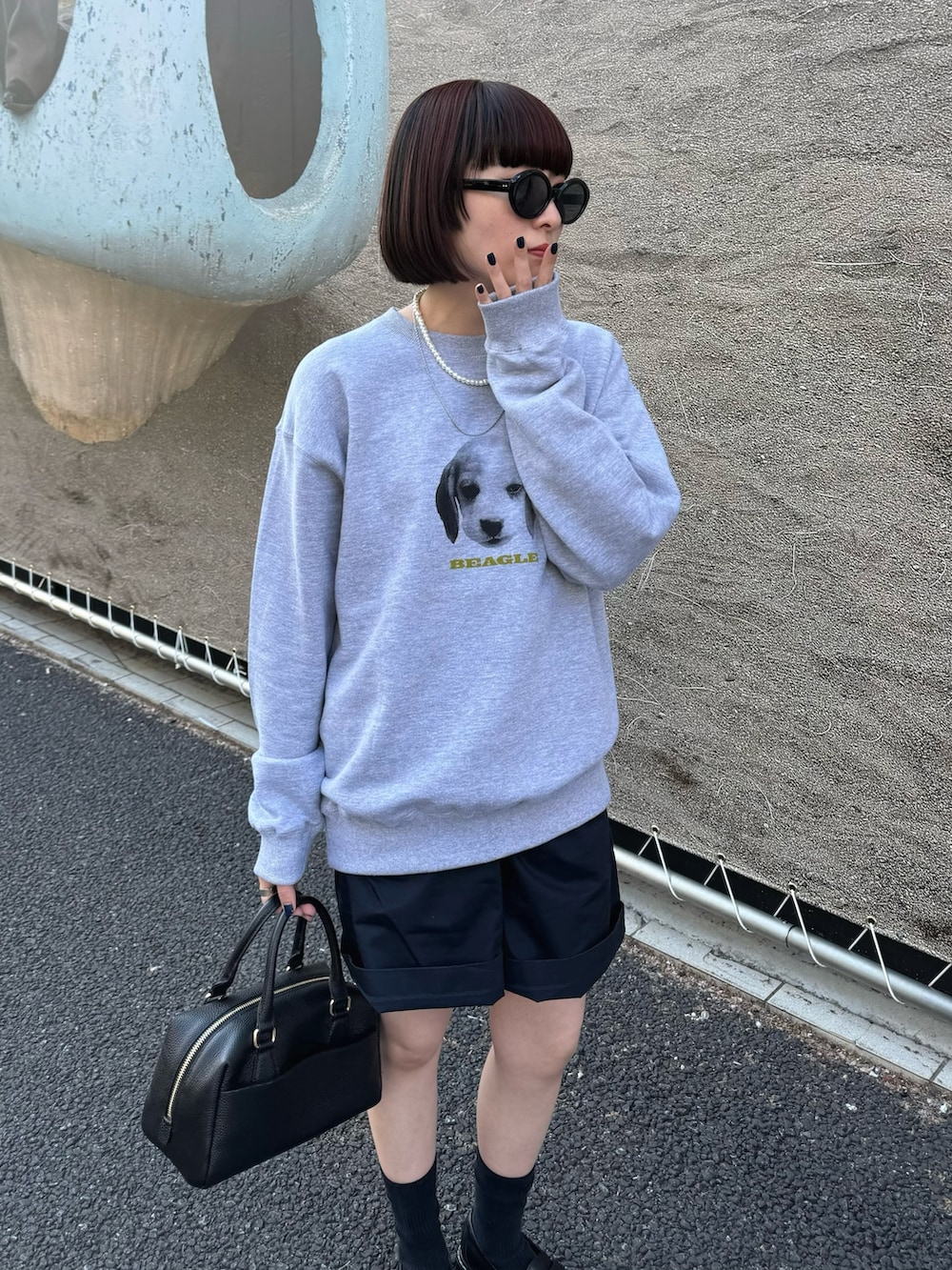 グレー系のスウェット、ブラック系のボストンバッグ、ブラック系のローファーを着用したレディースの春コーディネートの3枚目の写真