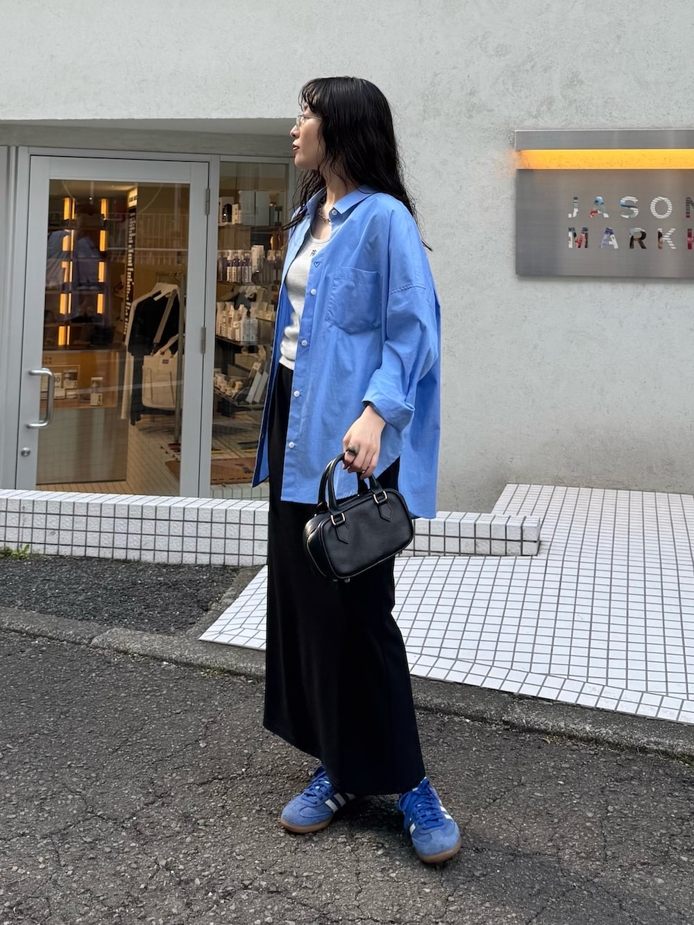 ブルー系のシャツ/ブラウス、グレー系のタンクトップ、ブラック系のスカートを着用したレディースの春コーディネートの5枚目の写真