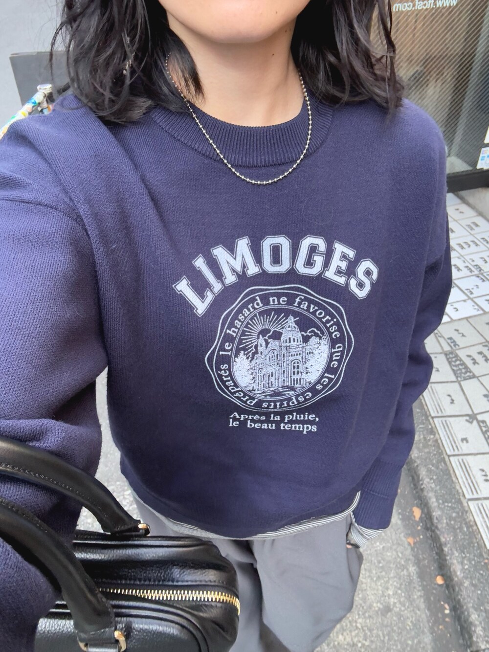 ブルー系のニット/セーター、グレー系のその他パンツ、ブラック系のハンドバッグを着用したレディースの冬コーディネートの6枚目の写真