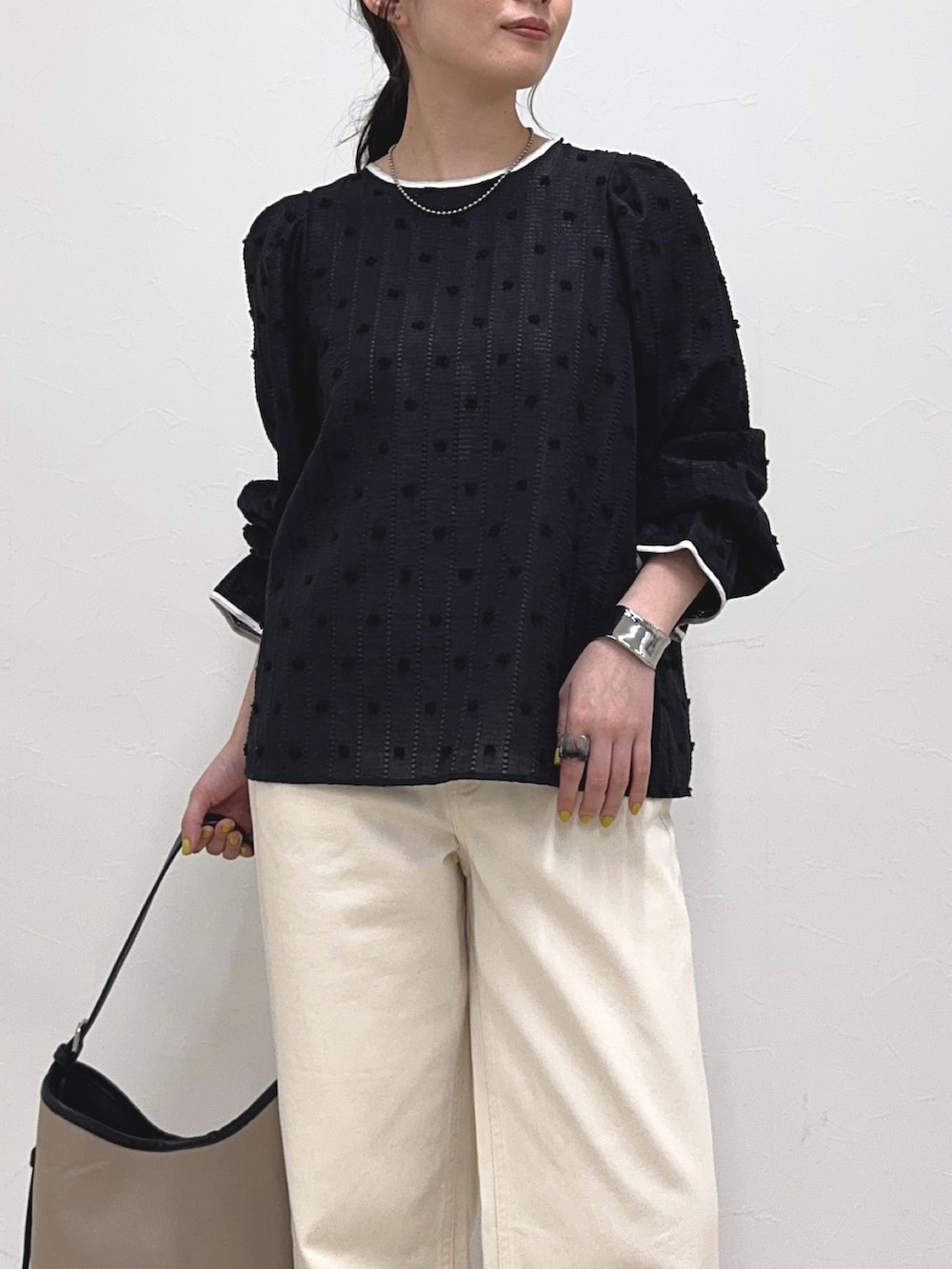 ブラック系のシャツ/ブラウス、ホワイト系のデニムパンツ、ブラック系のショルダーバッグを着用したレディースの春コーディネートの5枚目の写真