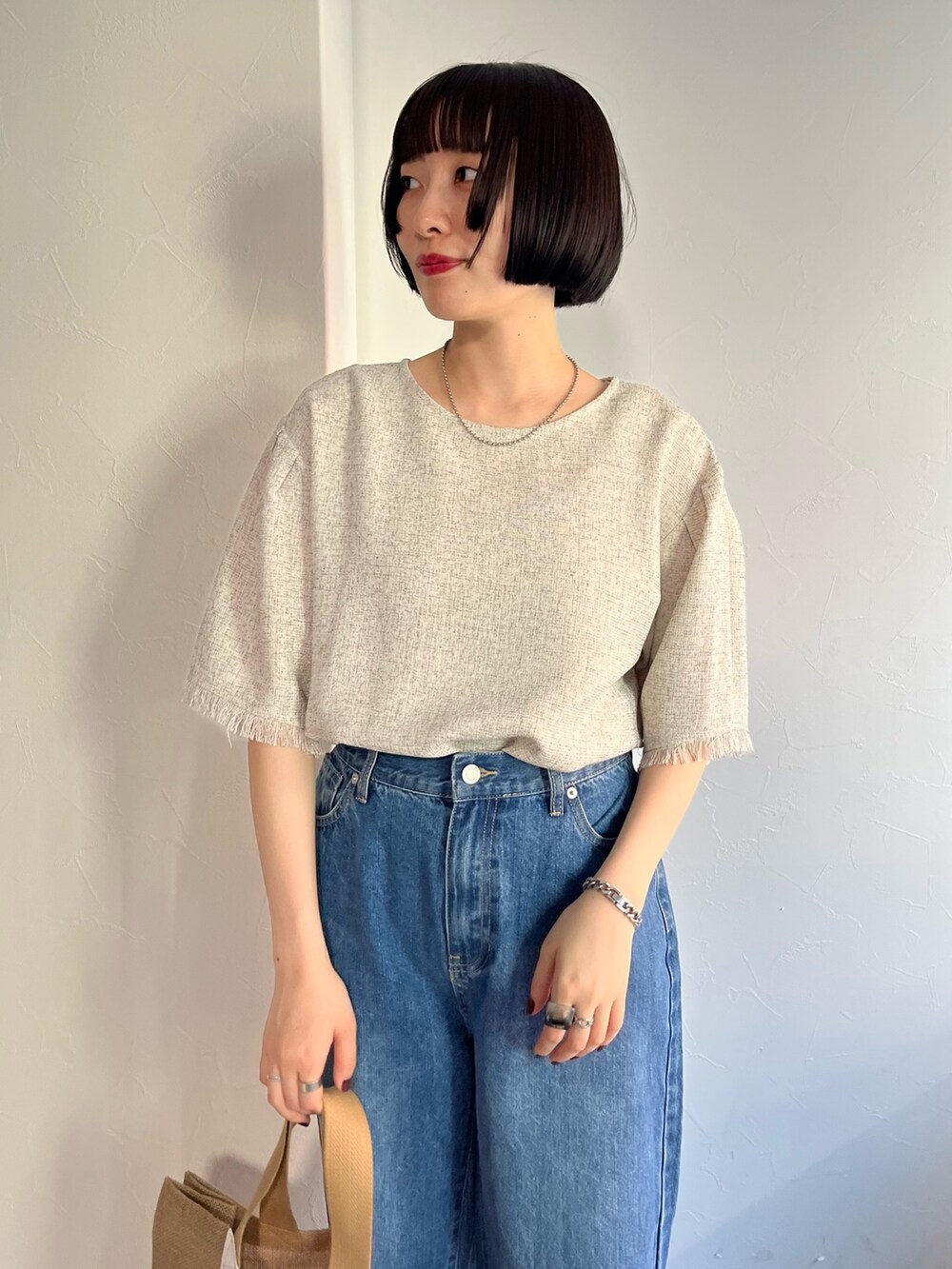 ホワイト系のシャツ/ブラウス、ブルー系のデニムパンツ、ベージュ系のバッグを着用したレディースの春コーディネートの4枚目の写真