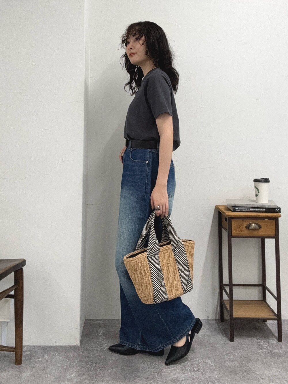 グレー系のTシャツ/カットソー、ブルー系のデニムパンツ、ベージュ系のかごバッグを着用したレディースの夏コーディネートの3枚目の写真