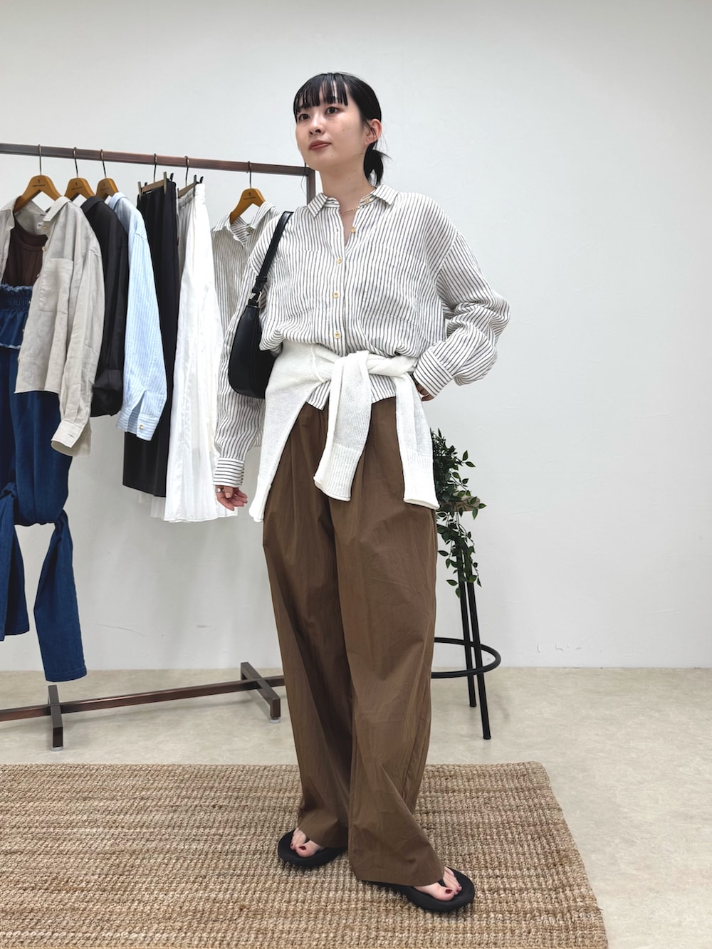 ベージュ系のシャツ/ブラウス、ブラウン系のその他パンツ、ホワイト系のニット/セーターを着用したレディースの春コーディネートの2枚目の写真