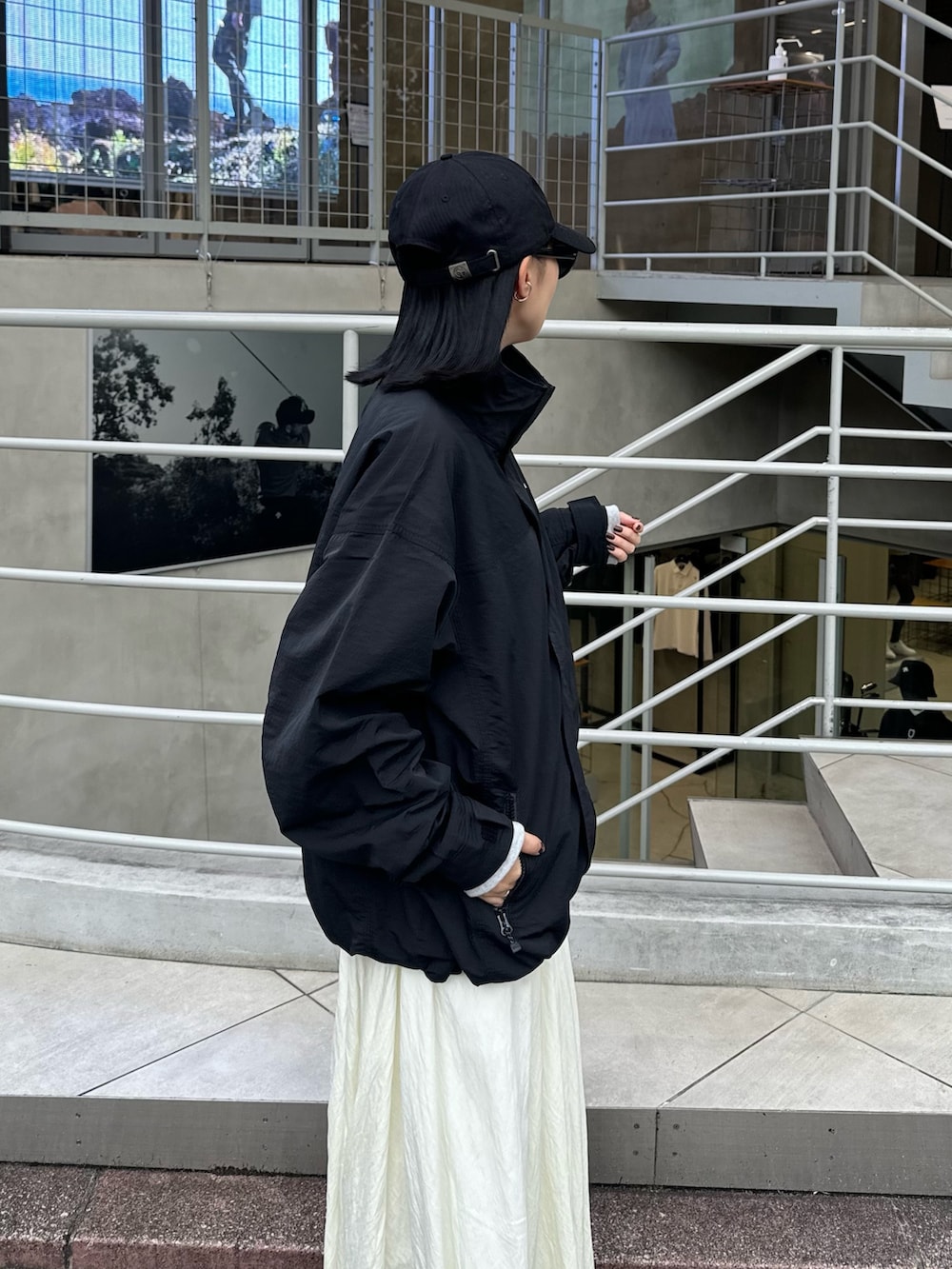 ホワイト系のスカート、グレー系のスウェット、ブラック系のマウンテンパーカーを着用したレディースの秋コーディネートの7枚目の写真