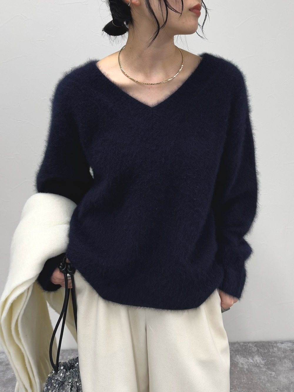 ブルー系のニット/セーター、ホワイト系のその他パンツ、ホワイト系のストール/ショールを着用したレディースの冬コーディネートの5枚目の写真