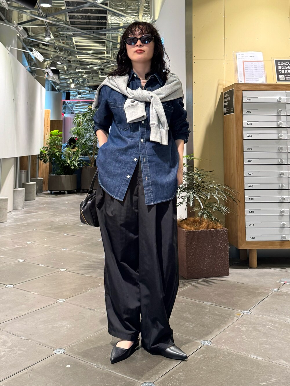 グレー系のスウェット、ブラック系のその他パンツ、ブラック系のショルダーバッグを着用したレディースの春コーディネートの6枚目の写真